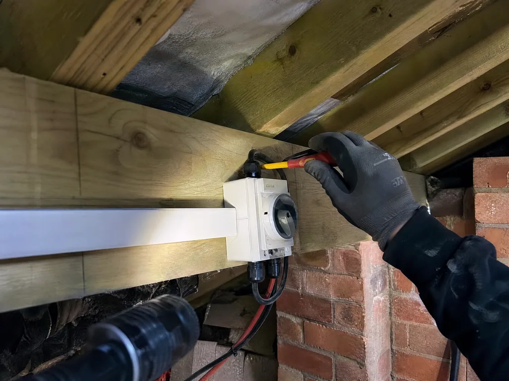 DC isolator being tested in a loft during a solar service, Derby