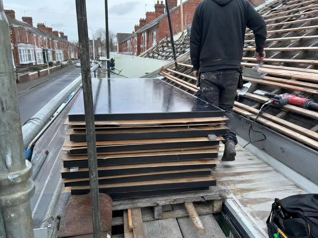 Solar panels lifted and stacked on the scaffold for roof work, Derby