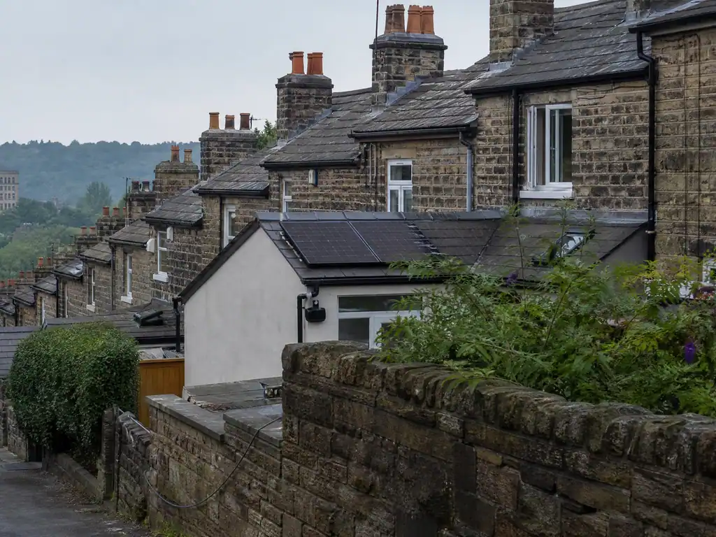 Solar panels on the rear roof of a stone terraced cottage in Belper